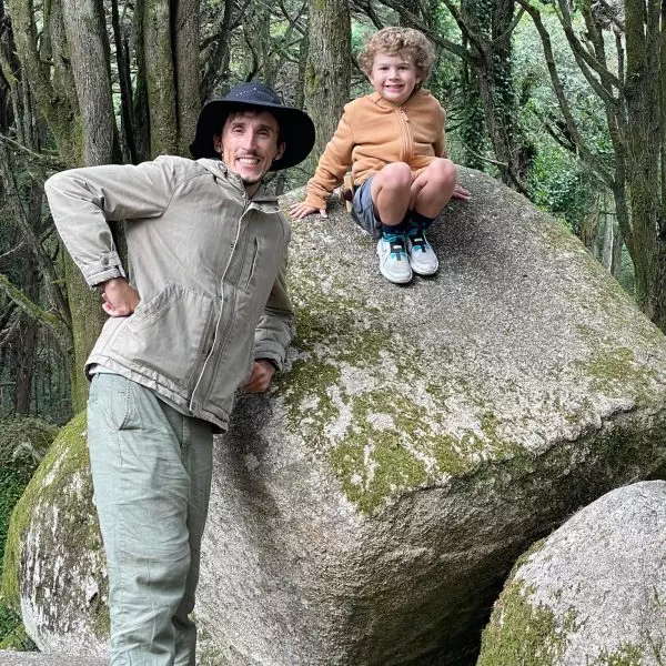 Daniel Ponce with a young boy on a large mossy boulder in the Sintra forest, Portugal – enjoying a nature break during a private family-friendly tour with Yes, You Deserve!