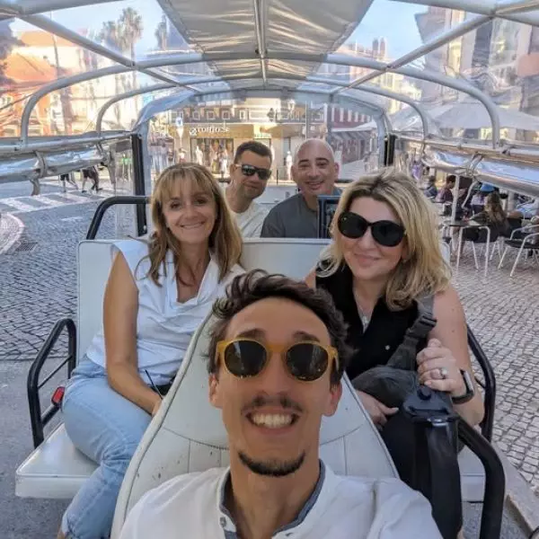 Group of tourists enjoying a sunny private tuk tuk tour in the historic center of Sintra with Daniel Ponce from Yes, You Deserve! – exploring charming cobblestone streets and colorful architecture in comfort.
