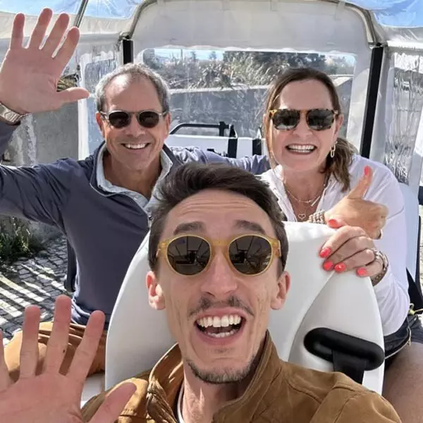 Tour guide Daniel Ponce takes a selfie with two happy guests during a Yes, You Deserve tuk-tuk tour in Sintra. All three are smiling and waving, enjoying the sunny weather and the adventure-filled experience.