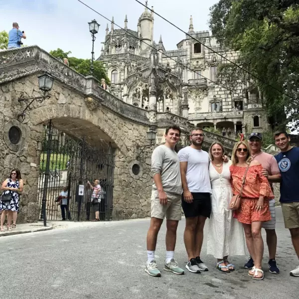Tourists in front of Quinta da Regaleira entrance in Sintra, Portugal – group photo with the famous neo-Gothic palace in the background